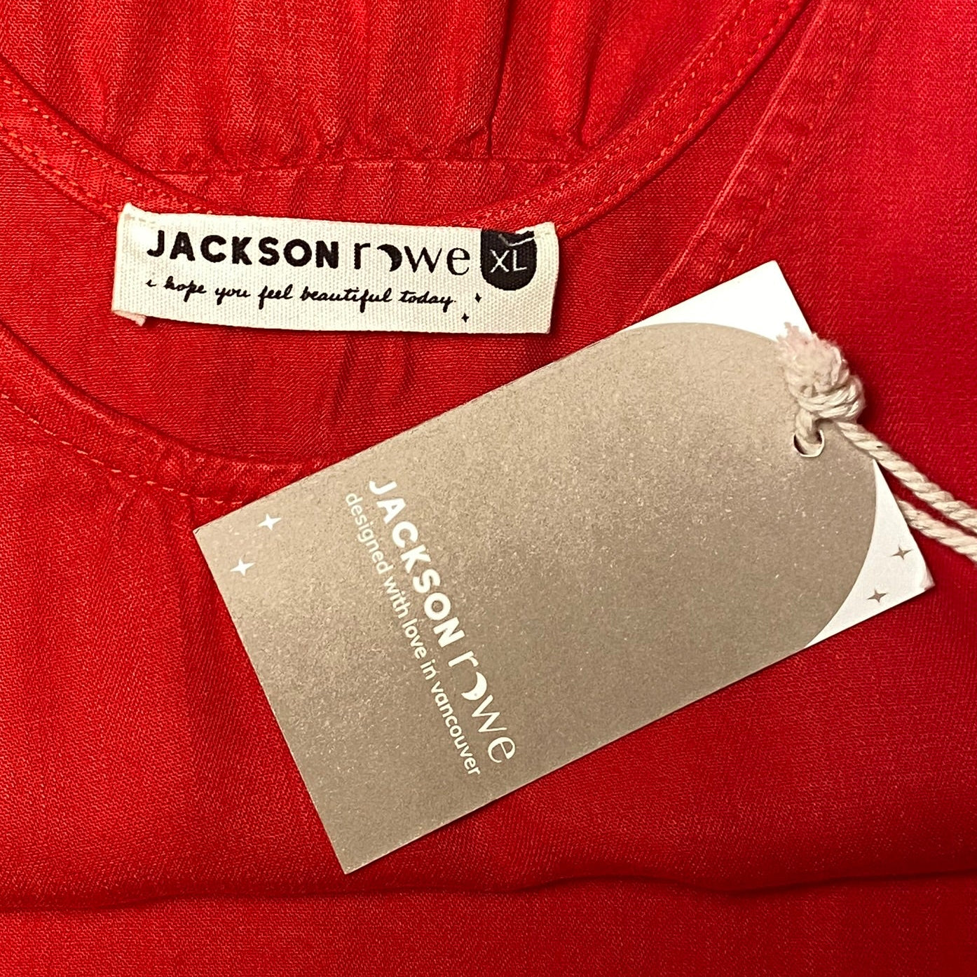 Product tag or label for the Jackson Rowe red "They Say" dress in midsize XL